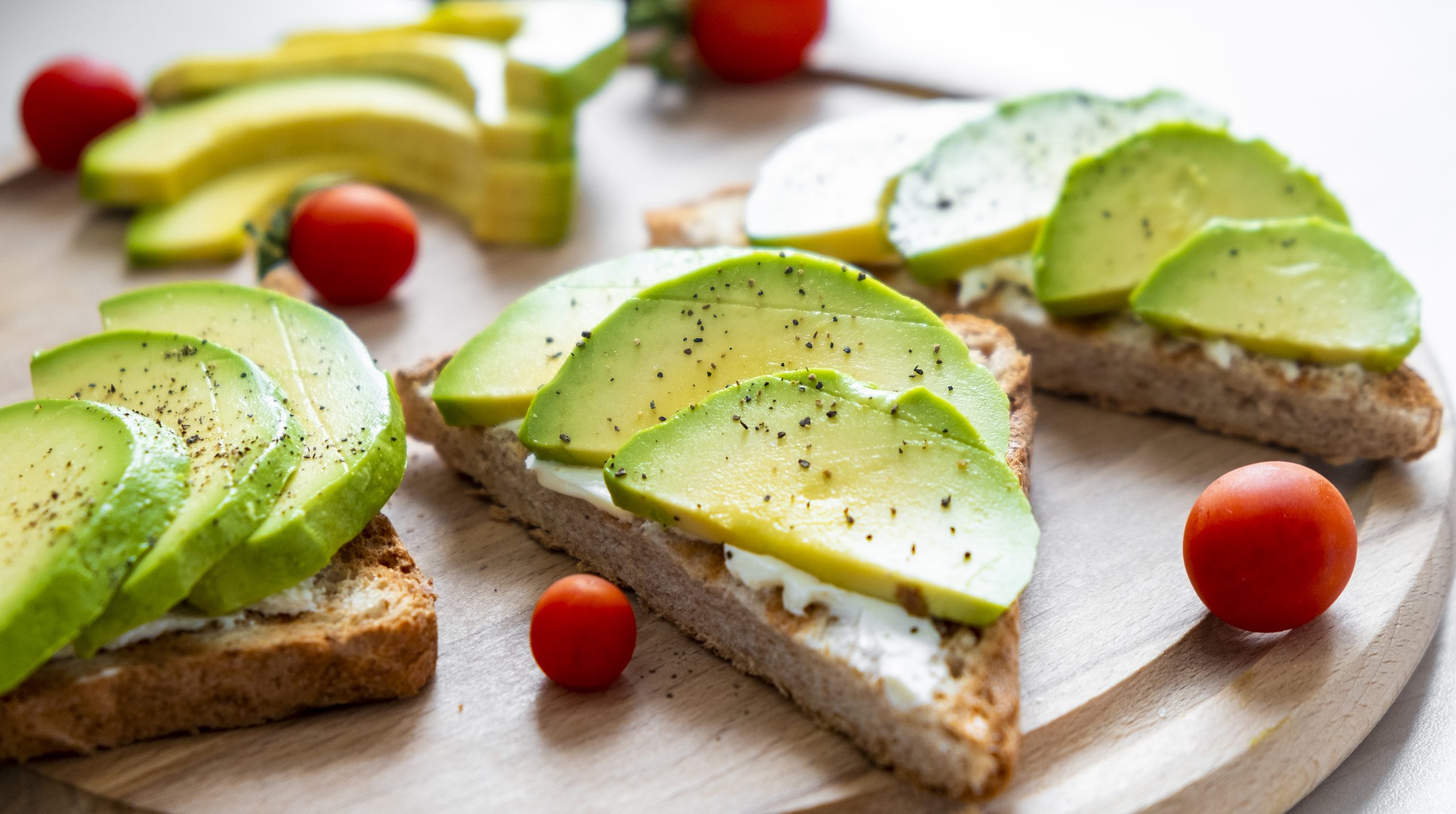 Healthy avocado toast with soft cheese, sliced avocado, cherry tomatoes and pepper on toasted bread for breakfast or lunch. Healthy snack, easy recipe of vegaterian bruschetta. Clean eating.